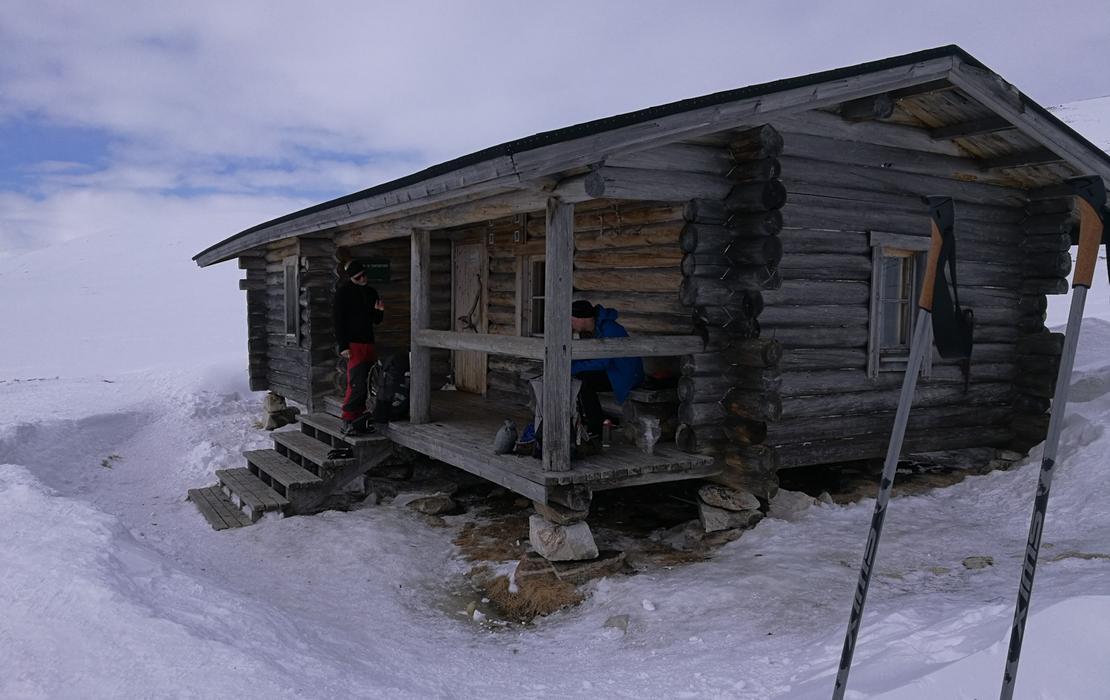 Remote winter cabin standing alone in a snowy Arctic wilderness.